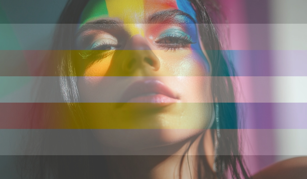 Close-up of a person with rainbow light across their face, overlaid with translucent demigender pride flag stripes
